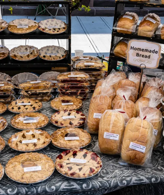 Breads and pies available for sale at a farmers market.